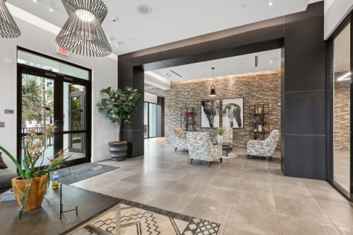 a lobby with chairs and a table and a glass door