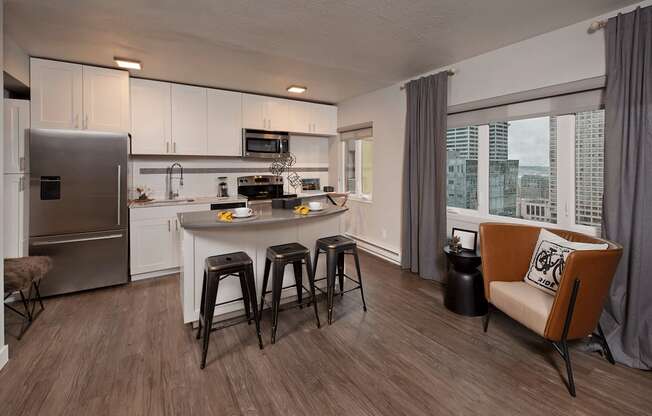 A modern kitchen with a refrigerator , stove, and bar stools