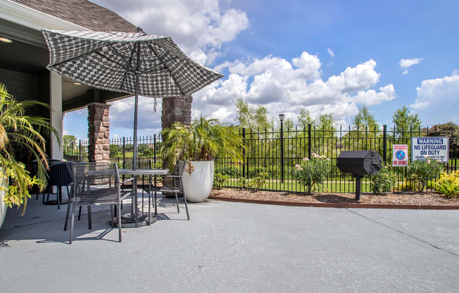 a patio with a table and chairs and an umbrella and a grill at Reserve by the Lake, Houston, TX, 77084