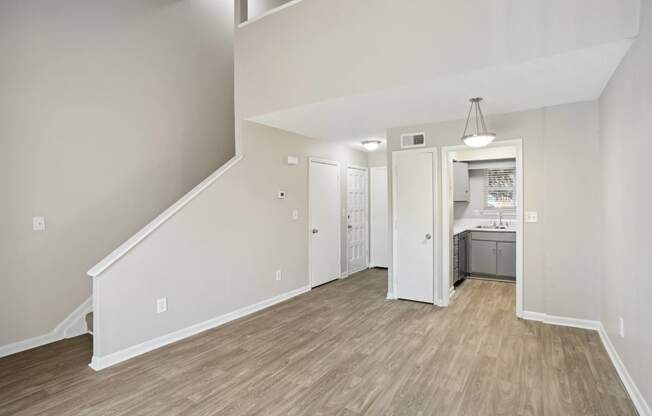 the living room and kitchen of a new home with white walls and wood flooring  at Emerald Bay, North Carolina