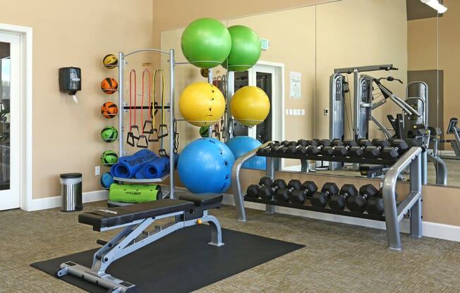 a gym with weights and other exercise equipment at the retreat at thousand oaks apartments