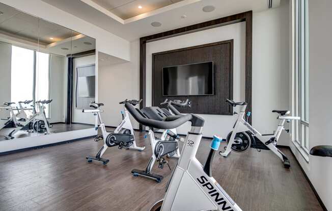 a gym with exercise bikes and a flat screen tv