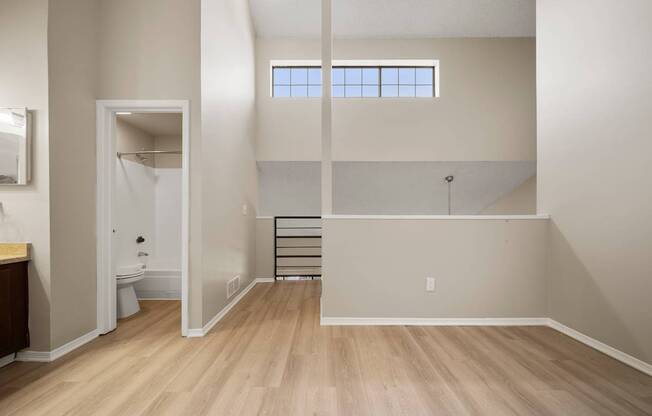 A bathroom with a toilet, sink, and a window.