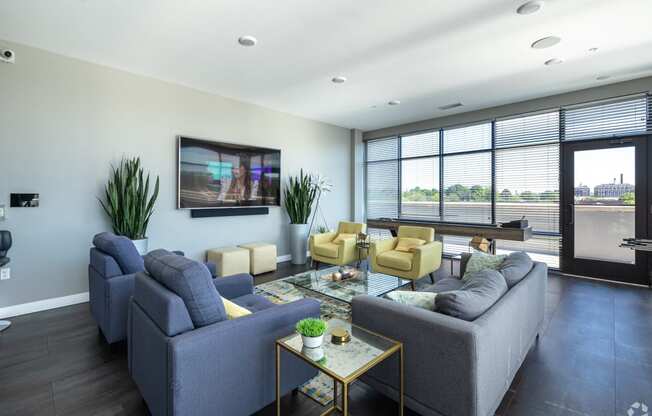 a living room with couches and chairs and a television on the wall