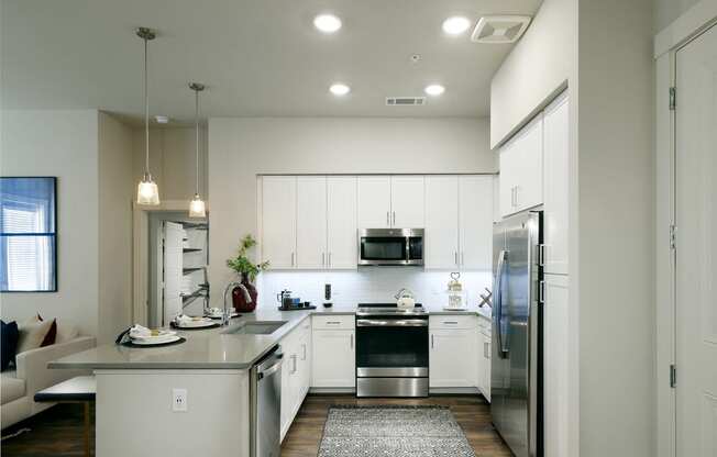 a large kitchen with white cabinets and stainless steel appliances