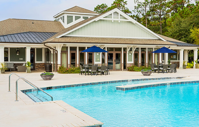 Pool with clubhouse and picnic tables at The Reserve at Mayfaire Apartments, Wilmington NC