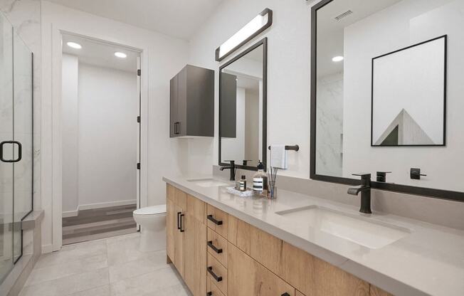 a bathroom with two sinks and two mirrors