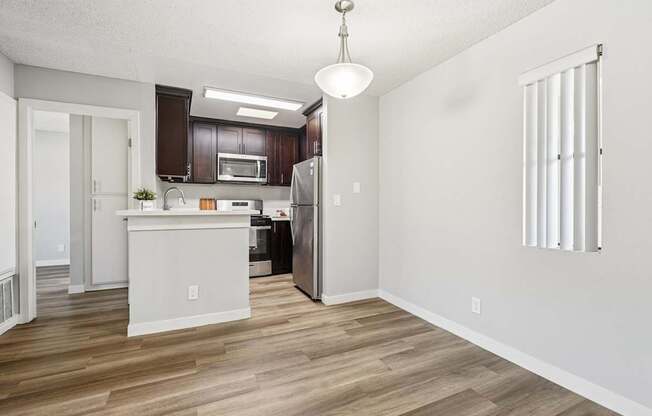 A kitchen with a white island and wooden floors.