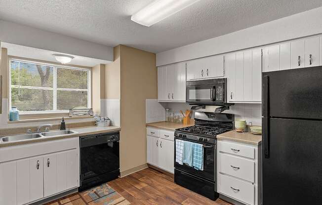 a kitchen with black appliances and white cabinets