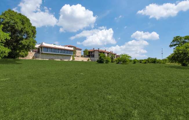 a large grassy field with a building in the background