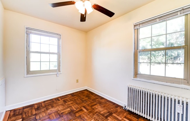 vacant bedroom with hardwood flooring and ceiling fan at the richman apartments in washington dc