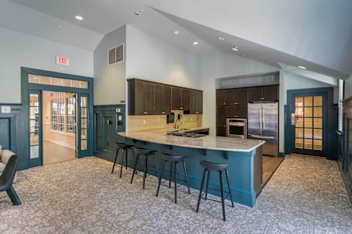 A kitchen with a bar area and a green exit door.