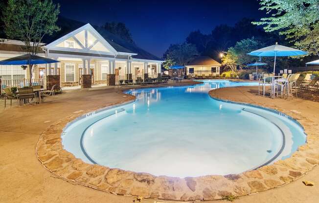 a pool with chairs and umbrellas at night at the resort at Highlands Apartment Homes, Bartlett, 38135