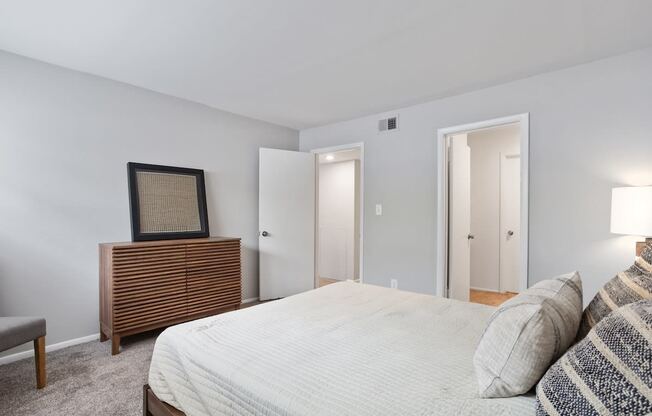 a spacious bedroom with model furnishings and plush carpeting