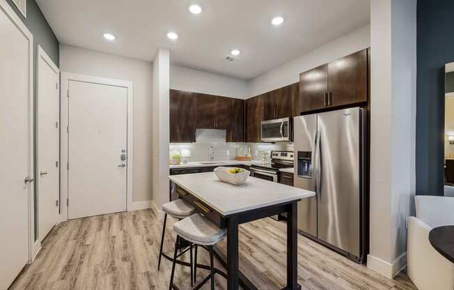 a kitchen with stainless steel appliances and a island with two stools