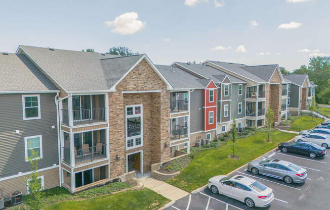 an aerial view of an apartment complex with cars parked in a parking lot