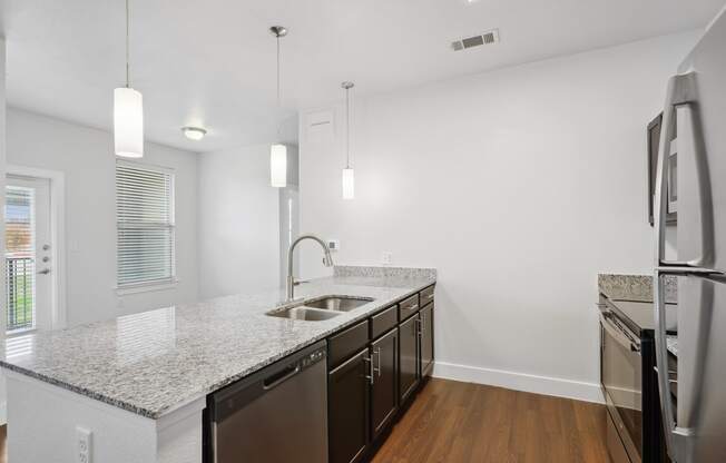 a renovated kitchen with granite counter tops and stainless steel appliances