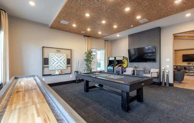 A room with a long wooden table and a television on the wall.