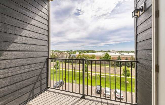 a balcony with a view of a yard and a balcony fence