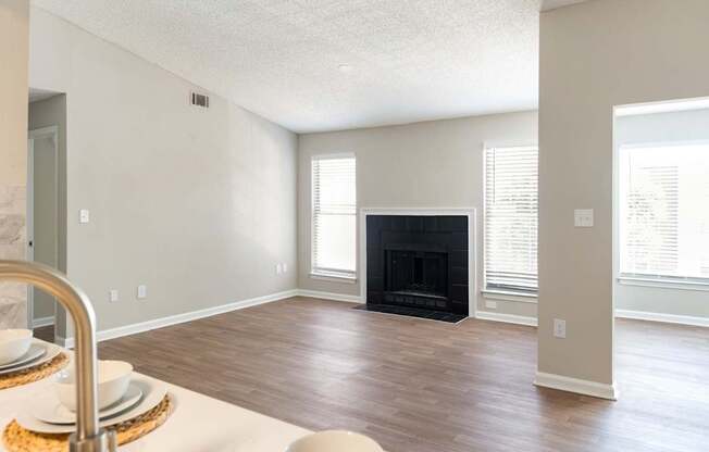 A modern living room with a fireplace and a dining table set for two.