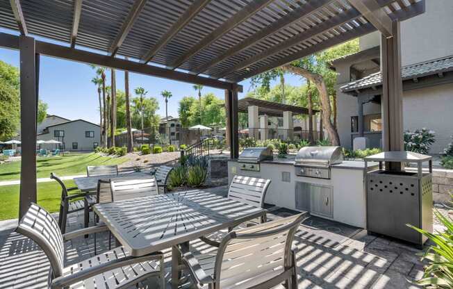 outdoor barbecue grilling area with chairs at lazo apartment homes