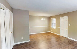 A room with wooden floors and white doors.