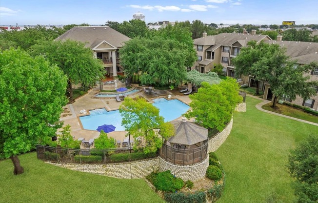 an aerial view of an apartment complex with a large pool in the middle of the yard