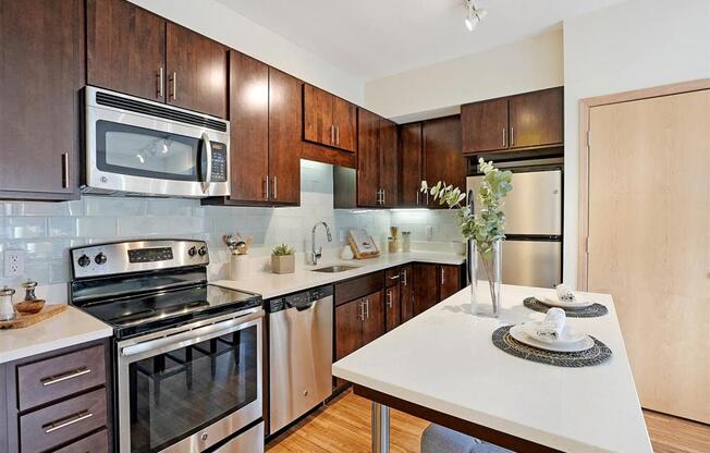 A kitchen with a stove, oven, microwave, and refrigerator.