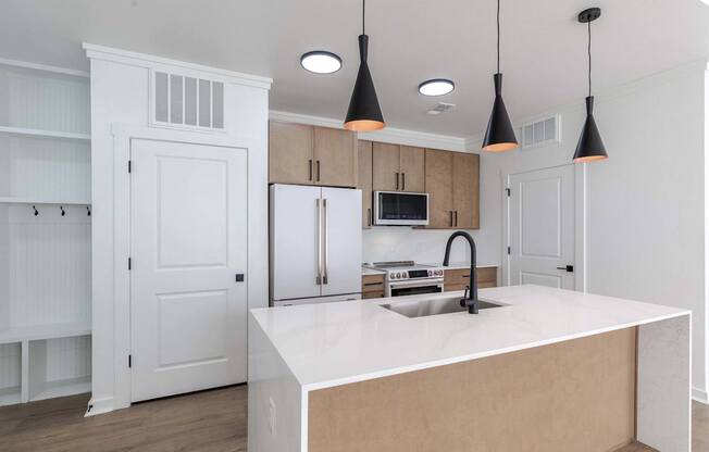 A kitchen with a white countertop and a sink.