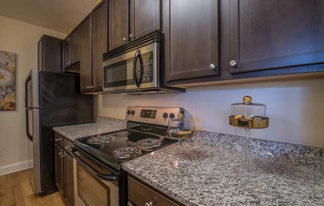 an updated kitchen with granite countertops and a stove and microwave
