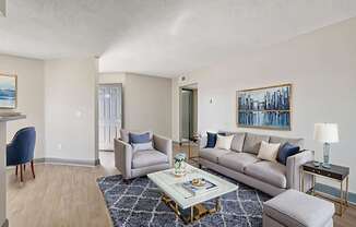 A living room with a grey couch, a blue chair and a coffee table.