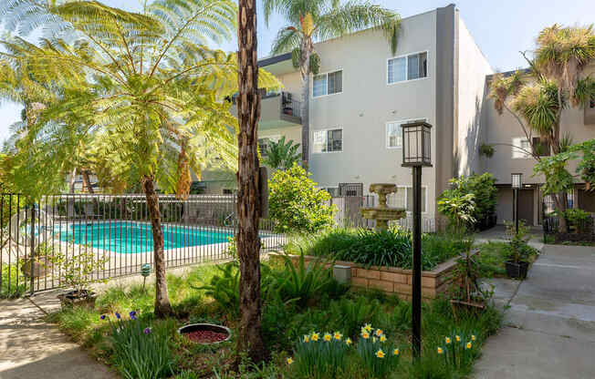 an apartment building with a swimming pool and palm trees