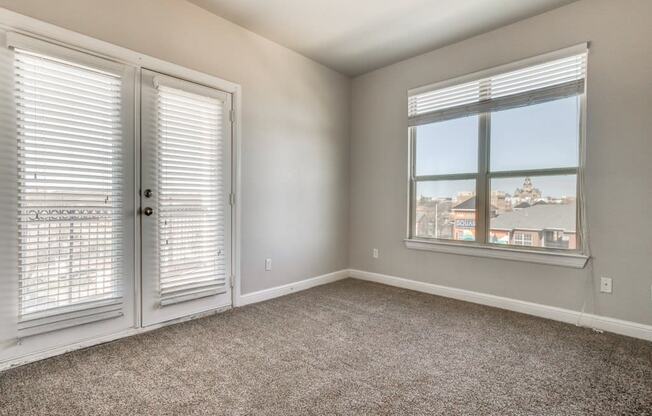 a bedroom with two windows and a door