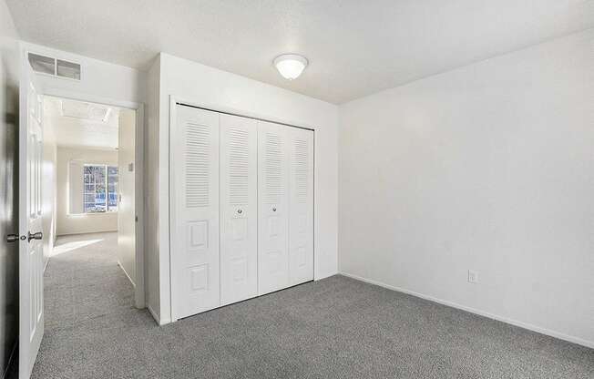 A white room with a grey carpet and a white door.