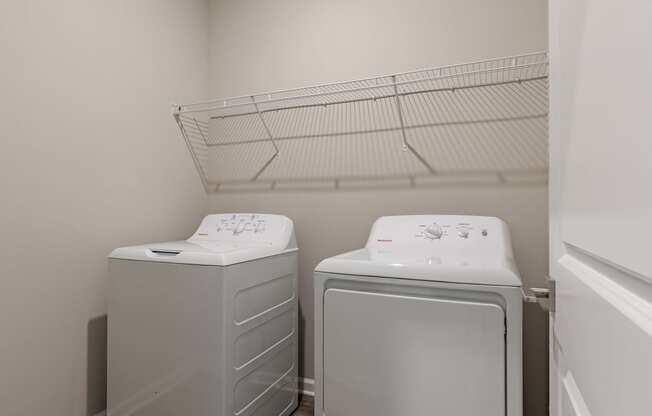 a washer and dryer in a laundry room with a rack on the wall