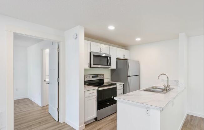 a kitchen with white cabinetry and stainless steel appliances