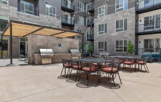 an outdoor patio with tables and chairs at an apartment building