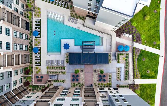 A swimming pool is surrounded by apartment buildings.