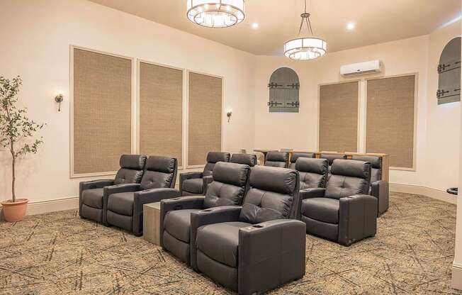 A room with a carpeted floor and a row of black leather chairs.