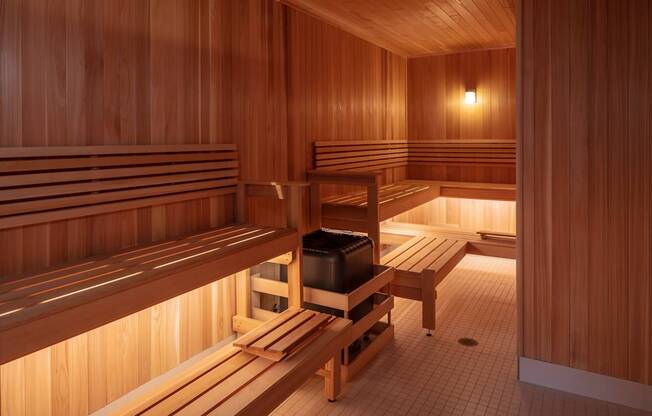 A wooden sauna room with benches and a table.