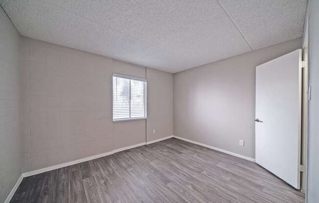 an empty living room with wood flooring and a white door