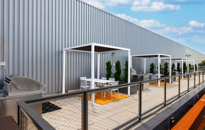 a rendering of the rooftop terrace of a building with tables and chairs