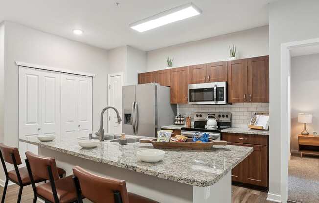 a kitchen with a granite counter top and a stainless steel refrigerator