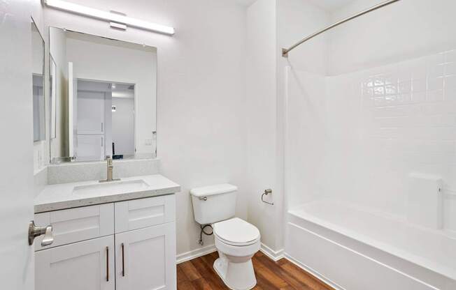A white bathroom with a toilet, sink, and bathtub.