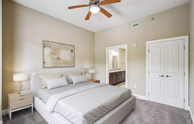 A bedroom with a large bed and a ceiling fan.