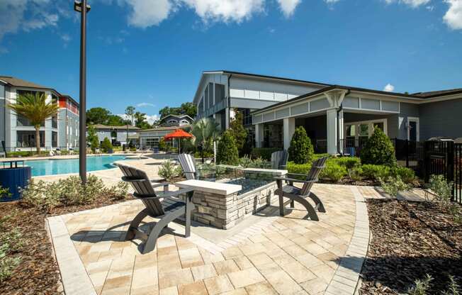 a patio with chairs and a table next to a swimming pool