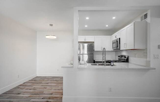 A kitchen with a stainless steel refrigerator, microwave, and oven.