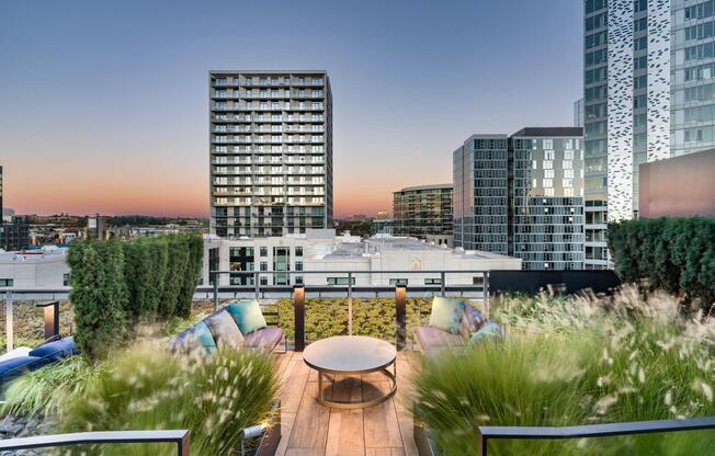 A rooftop lounge at Modera Pearl with city views, layered landscaping, and comfortable seating designed for relaxed evenings above Portland.
