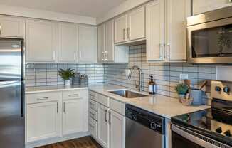 a kitchen with stainless steel appliances and white cabinets at The Rays at Vegas Towers Apartments, Las Vegas, Nevada