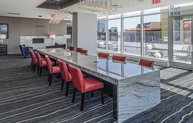 Co-working area at 3thirty3 New Rochelle NY high-rise, featuring a marble community table, modern furniture, and window wall with city skyline view.